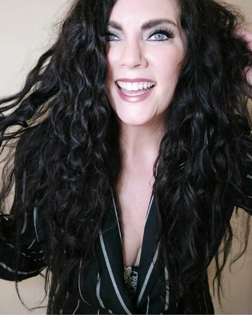 A woman with long black hair and blue eyes.