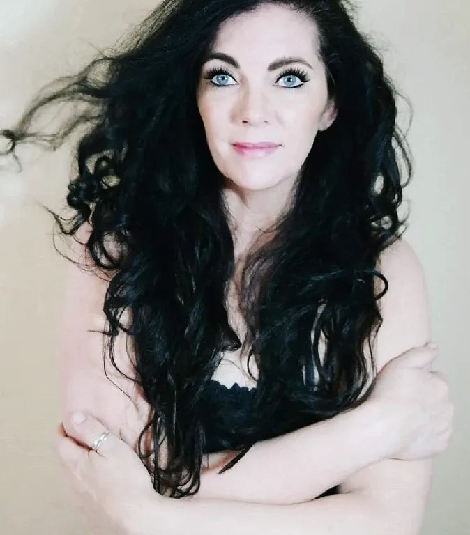 A woman with long black hair posing for the camera.