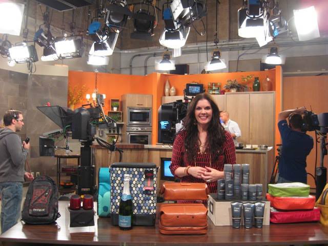 A woman standing behind a counter with many items.