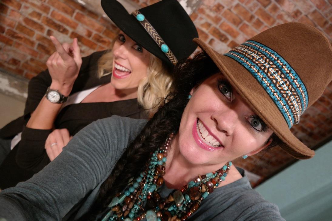 Two women wearing hats and smiling for a picture.